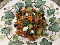 a white plate topped with lots of veggies and feta on top of it