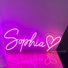 a neon sign that says sophiia on the side of a wall next to a vase