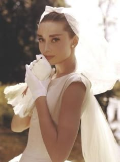 a woman dressed in white holding a stuffed animal