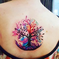 a woman with a colorful tree tattoo on her back