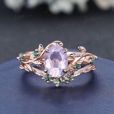 a ring with an oval stone surrounded by leaves