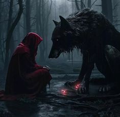 a person sitting on the ground next to a wolf with red lights in its eyes