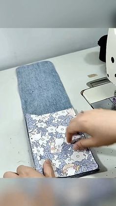 a person is using a sewing machine to sew something on a piece of fabric