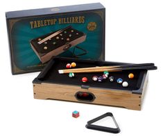 an old fashioned pool table with billiards and cues