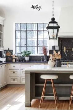 two stools sit at the center of a kitchen island in front of an open window