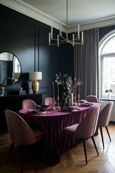 a dining room with purple chairs and a round table