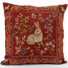 a red pillow with an embroidered rabbit on the front and floral designs on the back