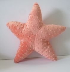 a pink starfish stuffed animal sitting on top of a white table