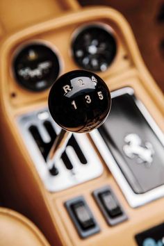 the interior of a sports car with buttons and gauges