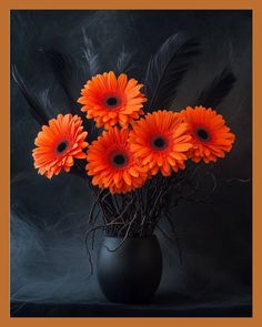 a black vase filled with orange flowers and feathers