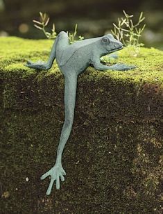 a statue of a lizard on top of a mossy surface