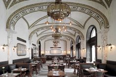 an ornately decorated dining room with chandeliers hanging from the ceiling and wooden tables