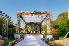 an outdoor wedding setup with flowers on the aisle