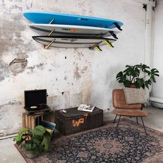 a living room with two surfboards hanging from the ceiling and a rug on the floor