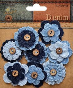 several blue and black flowers with buttons in the middle on a piece of cardboard paper