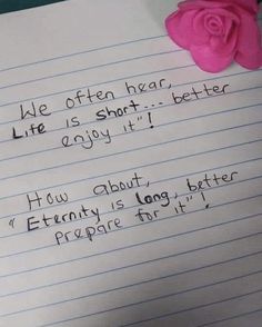 a piece of paper with writing on it and a pink rose sitting next to it