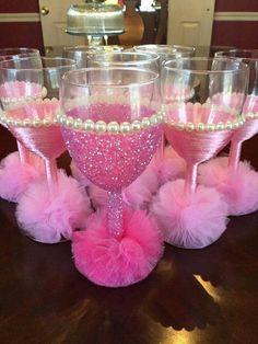 some wine glasses with pink and white decorations