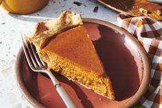 a slice of pumpkin pie on a plate with a fork