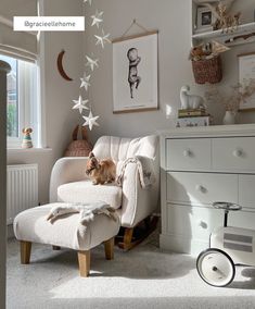 a cat is sitting on a chair in a room with white furniture and decorations around it