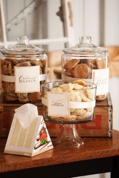 several glass containers filled with food on top of a wooden table next to other items