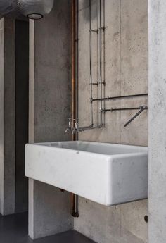 a white sink sitting in the middle of a bathroom next to a wall mounted faucet