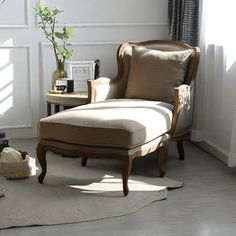 a living room with a chair, table and potted plant on the floor in front of it