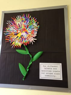 a flower made out of colored crayons on a bulletin board