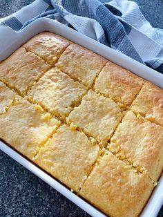 a casserole dish filled with yellow squares on top of a blue and white towel