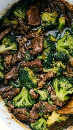 beef and broccoli in a pot with a wooden spoon