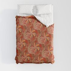 an orange and red comforter with white pillows