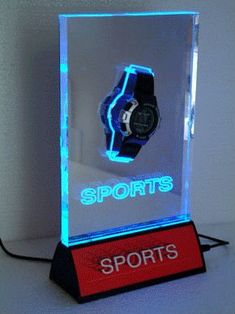 a lighted display case with a watch on it's side and the words sportss below