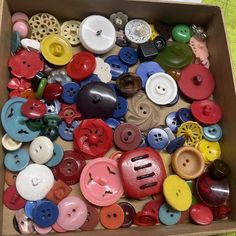 a box filled with lots of different colored buttons