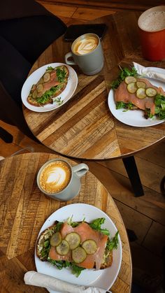 two plates with food on them sitting on a table next to a cup of coffee