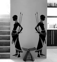 two black and white silhouettes of women with arrows in their hair, standing next to each other