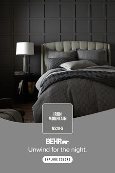 the bed is made up with grey sheets and pillows, along with an iron mountain logo