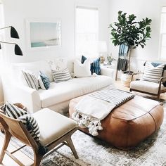 a living room filled with white furniture and pillows