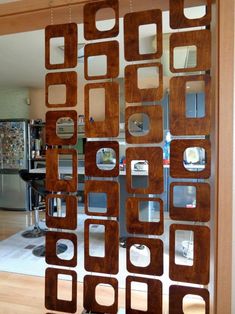 an open glass door with wooden squares and circles on it in front of a dining room table