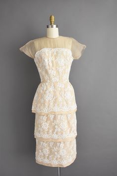 "Outstanding vintage 1950s cocktail party dress by Irene Sargent. This vintage dress features a wonderful Chantilly lace over lace with a gorgeous tier pencil skirt. The bodice is well fitted with bust darts, nipped waist, and a back metal zipper for closure. ✂------ M E A S U R E M E N T S ------- Best Fit: Small Bust: 32.5/33\" Waist: 24.5/25\" Hips: 37.5\" Shoulders: undefined Sleeves: 3.5\" Total Length: 44.5\" Tag/Label: Irene Sargent Material: Chantilly lace, silk Condition: Excellent vint Elegant Vintage White Dress With Scalloped Lace, 1950s Style Cream Evening Dress, 1950s Cream Party Dress, 1950s Style Cream Party Dress, White Vintage Cocktail Dress, Cream Fitted Lace Dress For Garden Party, Vintage White Dress With Scalloped Lace For Vintage Events, 1950s Style Cream Dress, Vintage White Dress With Scalloped Lace