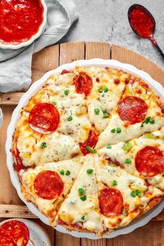 a pizza sitting on top of a white plate covered in cheese and pepperoni slices