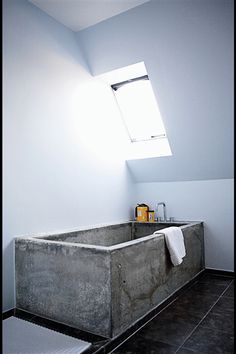 a bathroom with a skylight above it and a bathtub in the middle of the room