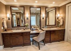 a large bathroom with two sinks, mirrors and a chair in front of the sink