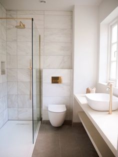 a bathroom with a sink, toilet and stand up shower in the middle of it