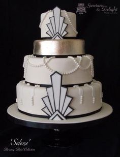 a three tiered wedding cake with white and black decorations