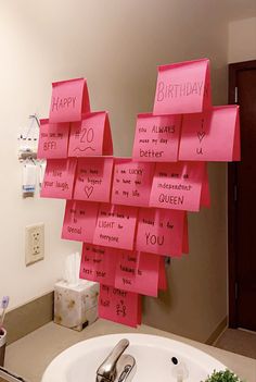 a bathroom sink with pink sticky notes attached to it