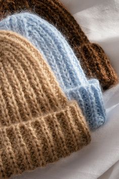 three knitted hats laying on top of each other