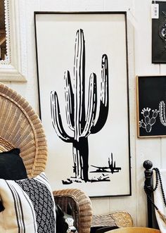 a living room filled with lots of furniture and art on the wall next to a wicker chair