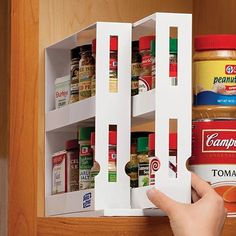 a person is opening the spice rack with their fingers