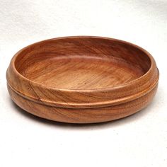 a wooden bowl sitting on top of a white table