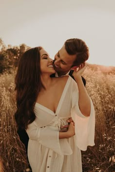 a man and woman standing in tall grass