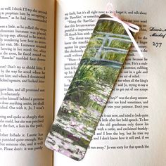 an open book with a watercolor painting on it and a white ribbon tied to the cover